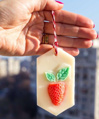 Tableta odorizanta din ceara naturala ornata cu o capsuna rosie cu frunze verzi, lucrata manual